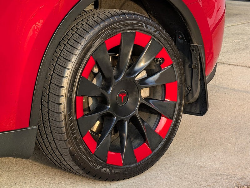 Close-up detail showing the precise fitment of a custom red vinyl decal overlay on a Tesla Model Y Induction wheel.