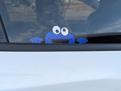 Blue creature sticker on a car window