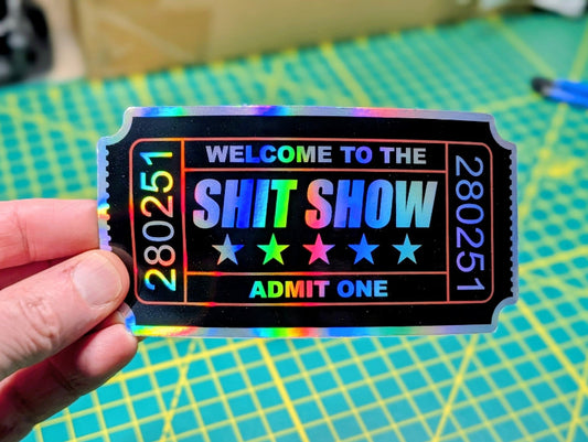A high-quality digital graphic of a "Welcome to the Shit Show" admission ticket decal with red accents, five stars, and a holographic shimmering texture on the white lettering and borders.