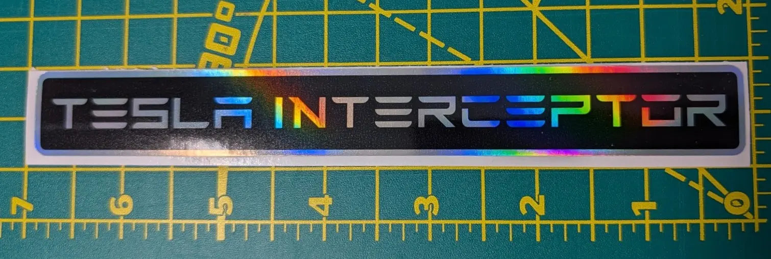 Tesla Interceptor logo on a reflective surface with a ruler below