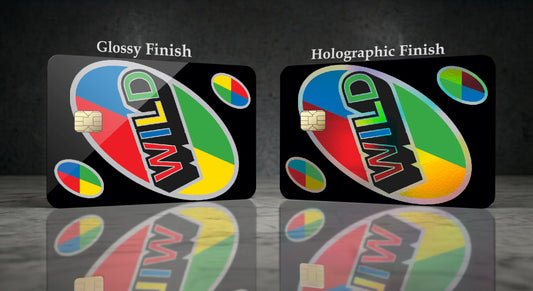 Two black cards labeled 'Glossy Finish' and 'Holographic Finish' with a colorful oval logo reading 'UNO WILD' and small multicolor circular graphics, shown on a dark reflective surface.